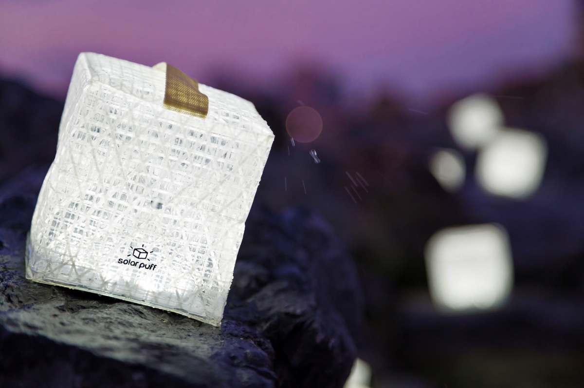 A portable solar-powered lantern placed on a rock